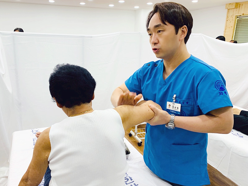 [사진설명] 광주자생한방병원 염승철 병원장이 진료소에 방문한 환자를 치료하고 있다