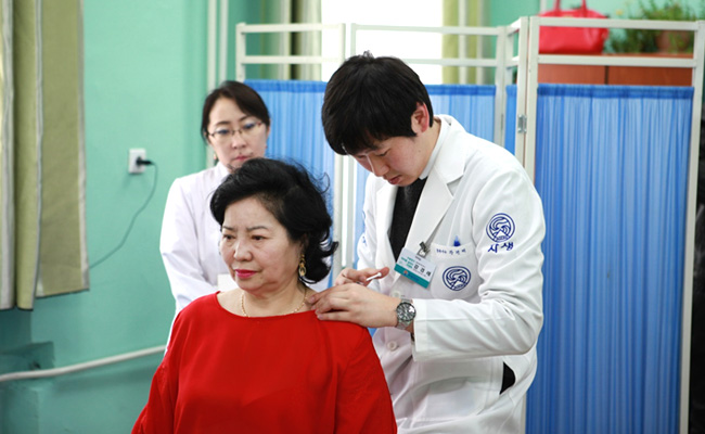 몽골 환자의 목에 약침치료를 하고있는 자생한방병원 홍보회 의료진